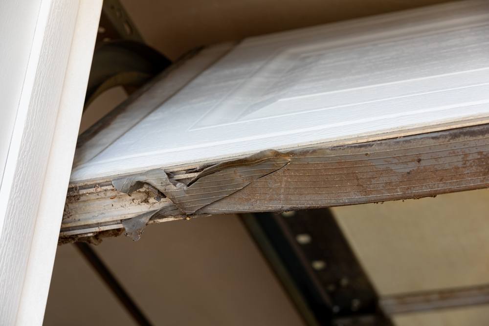 Overhead garage door weather stripping seal torn and broken.