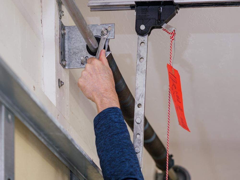 A garage door technician changing a garage door spring.