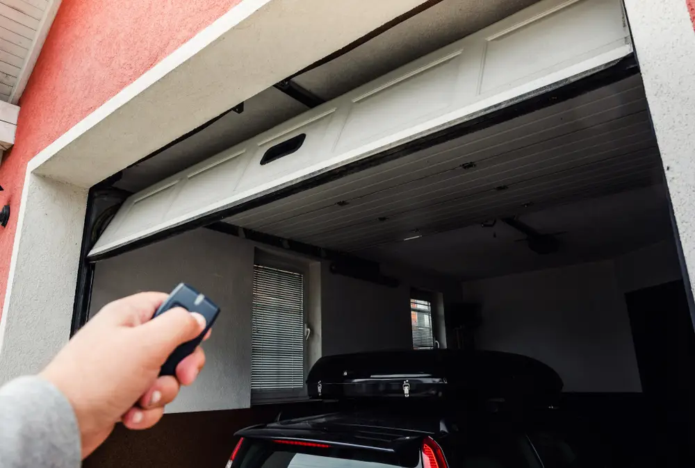 A person trying to close their garage door with a remote