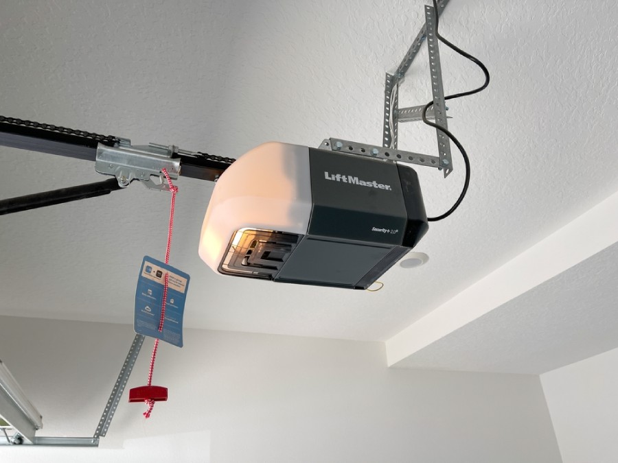 Automatic garage door opener with emergency release cable