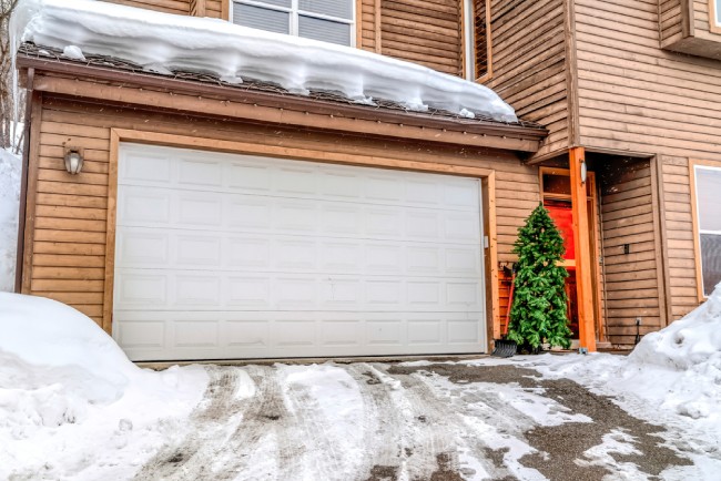 Snowy driveway in front of garage door