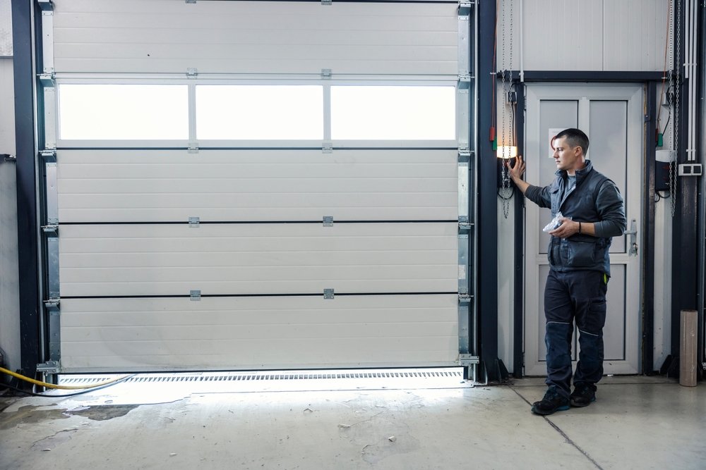A mechanic is pressing button and opening garage door